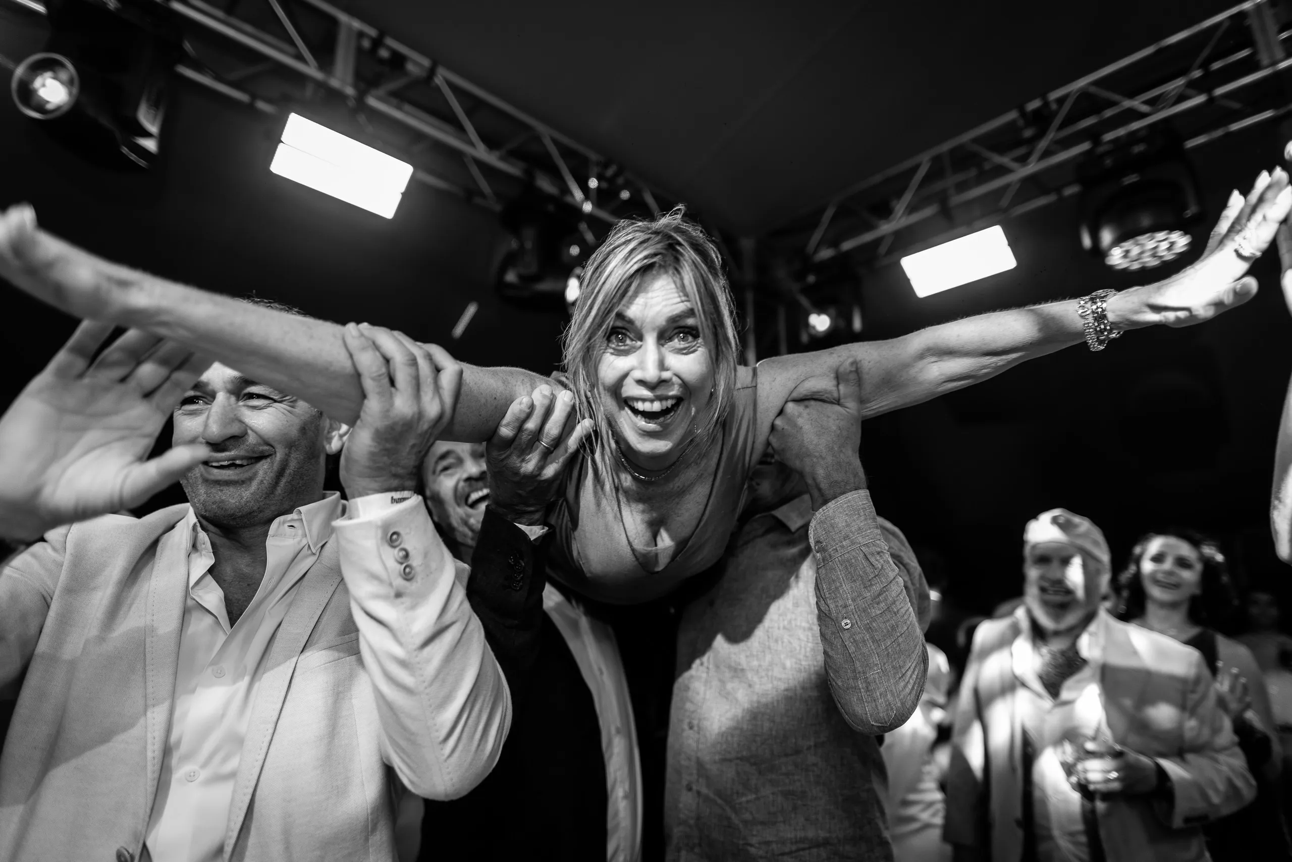 Dos invitados abrazados riéndose en plena fiesta, en blanco y negro