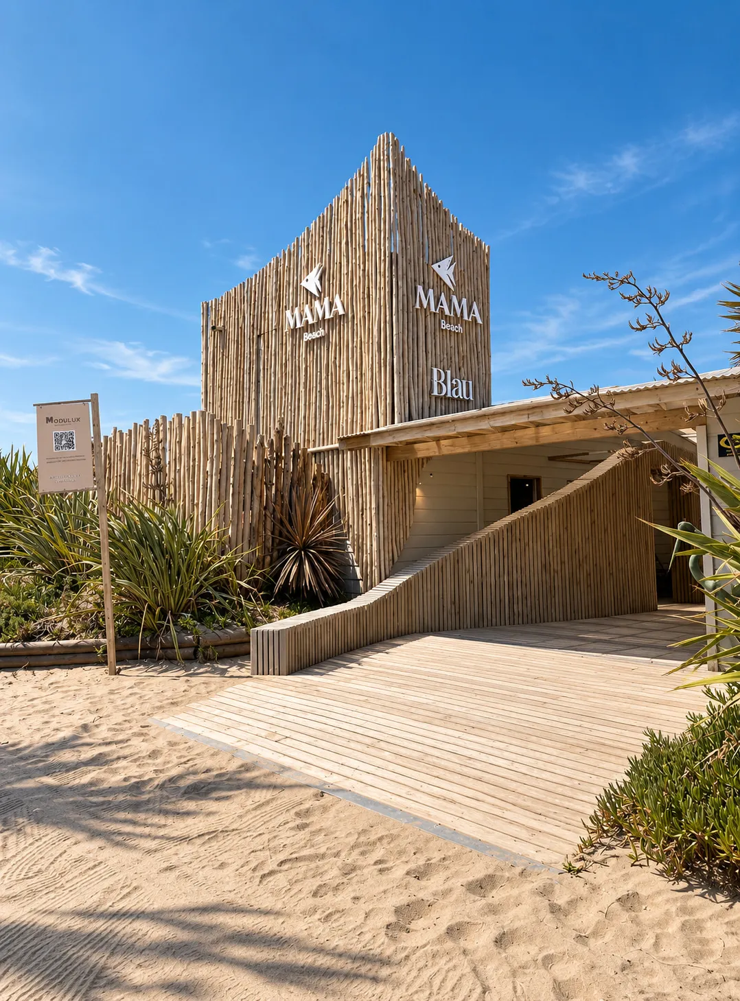 La entrada del parador de día, con la pasarela de madera sobre la arena