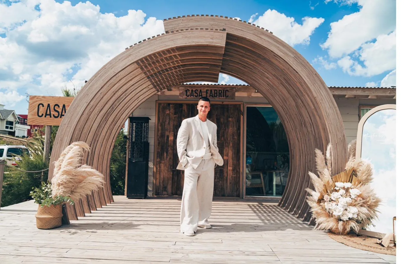 La fachada curva de madera de Casa Fabric, con pampas a los costados de la entrada