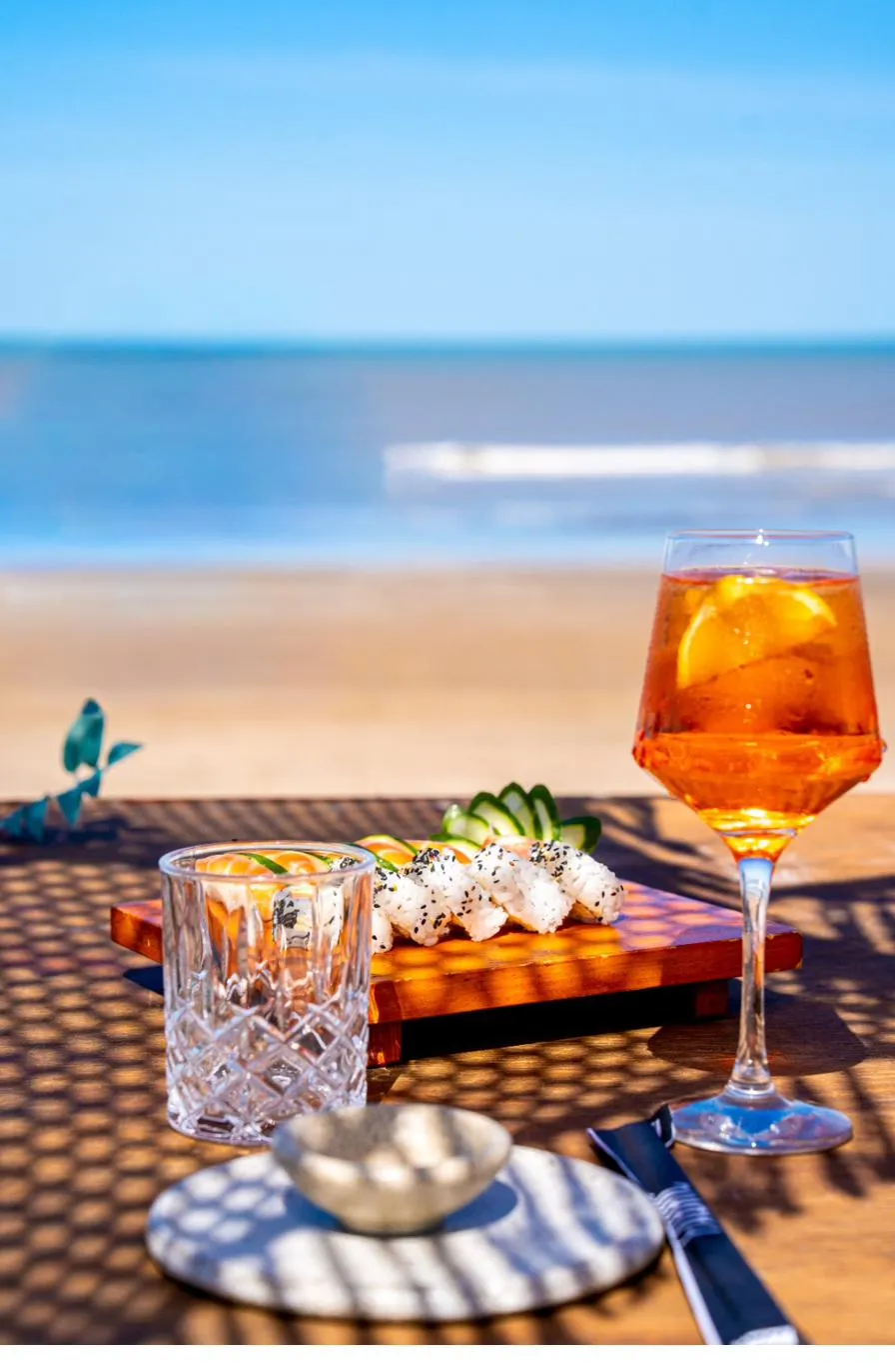 Aperol spritz y sushi servidos frente al mar