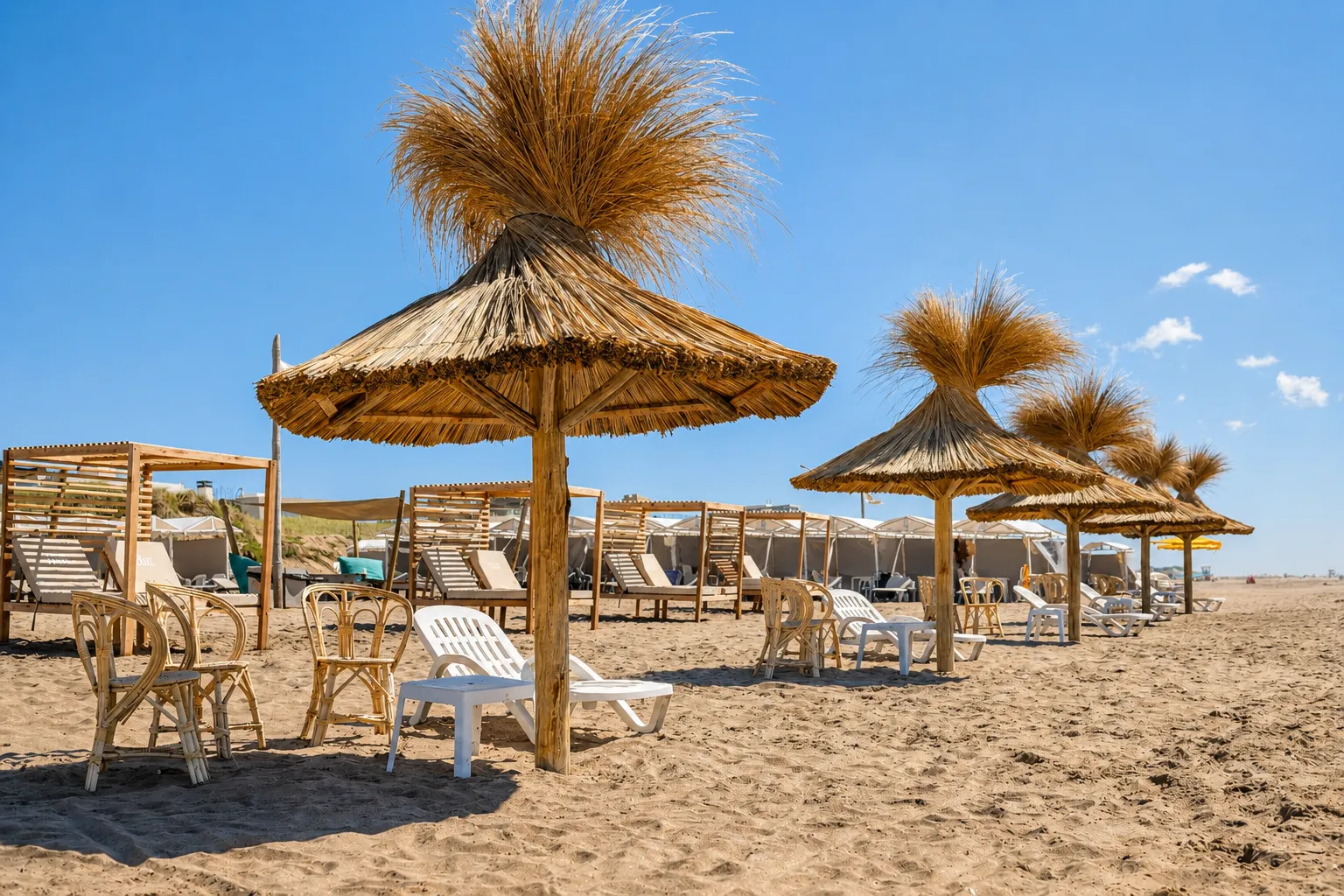 Palapas de quincho con reposeras sobre la arena de Mama Beach